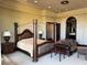 Large main bedroom showcasing a four-poster bed and a comfortable seating area at 1800 Amarone Way, Henderson, NV 89012