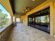 Expansive covered patio with decorative columns, travertine tile flooring, and large sliding glass doors at 1800 Amarone Way, Henderson, NV 89012