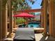 Inviting outdoor living space with a red umbrella, pool, and built-in grill for ultimate entertainment at 1800 Amarone Way, Henderson, NV 89012