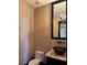 Stylish powder room with a dark vanity, bowl sink, stone countertop, and unique wall texture at 1800 Amarone Way, Henderson, NV 89012