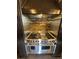 Gourmet stove and hood with red knobs, set against a stone tile backsplash at 1800 Amarone Way, Henderson, NV 89012