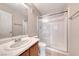 Bathroom with a white toilet, white tiled shower, and a wood vanity at 208 Genesee Point St, Henderson, NV 89074