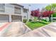 Two-story home features a two-car garage, manicured lawn, and mature trees in a desirable community at 208 Genesee Point St, Henderson, NV 89074