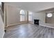 Bright living room features a fireplace, large arched windows, and stylish gray wood flooring at 208 Genesee Point St, Henderson, NV 89074