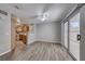 Open-concept living area featuring wood flooring, a ceiling fan, and sliding glass doors to the outdoors at 208 Genesee Point St, Henderson, NV 89074
