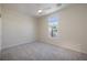 Carpeted bedroom featuring a ceiling fan, a modern arch window, and neutral walls at 2221 River Grove Dr, Henderson, NV 89044