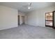 Main bedroom with soft gray carpet, neutral walls, a ceiling fan and access to a screened-in patio at 2221 River Grove Dr, Henderson, NV 89044
