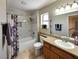 Bright bathroom with a shower/tub combo, granite countertop vanity, and a framed mirror at 2451 Muirfield Ave, Henderson, NV 89074