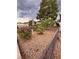 View of the private fenced backyard with low-maintenance rock landscaping and mature trees at 2504 Libretto Ave, Henderson, NV 89052