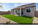 Private backyard featuring lush artificial turf, a covered patio, and desert landscaping at 2615 Regency Cove Ct # Lot 13, Las Vegas, NV 89121
