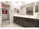 Bathroom featuring dual sinks, a large vanity mirror, and walk-in closet access at 2860 Sunflower Days Ave # 2141, North Las Vegas, NV 89031