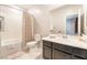 This bathroom features a shower-tub combo, neutral tile and a dark vanity cabinet at 2860 Sunflower Days Ave # 2141, North Las Vegas, NV 89031
