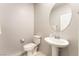 Elegant powder room features a pedestal sink with a round mirror and a modern toilet at 2860 Sunflower Days Ave # 2141, North Las Vegas, NV 89031