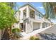 Stylish stucco townhome showcasing a private balcony, attached garage, and lush landscaping at 2860 Sunflower Days Ave # 2141, North Las Vegas, NV 89031