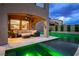 A covered patio with a sectional sofa overlooks a pool with green LED lighting and mature landscaping at 2862 Athens Ridge Dr, Henderson, NV 89052