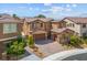 Aerial view of a two-story home boasting desert landscaping, a three car garage and a brick paved driveway at 2862 Athens Ridge Dr, Henderson, NV 89052
