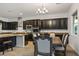 Open-concept kitchen and dining area with dark cabinets and granite countertops, ideal for entertaining at 2862 Athens Ridge Dr, Henderson, NV 89052