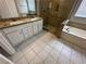 Bathroom featuring double sinks with granite counters, a shower, and a soaking tub at 316 Lingering Ln, Henderson, NV 89012