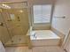 Bright bathroom featuring a glass shower and a soaking tub under a window at 316 Lingering Ln, Henderson, NV 89012