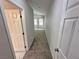 Hallway with carpet and white doors leading to carpeted room with windows at 316 Lingering Ln, Henderson, NV 89012