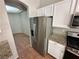 Kitchen boasts stainless steel refrigerator, modern appliances, granite countertops, and terracotta flooring at 316 Lingering Ln, Henderson, NV 89012