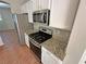 Kitchen with stainless steel appliances, tile floor, granite countertops, and white cabinets at 316 Lingering Ln, Henderson, NV 89012