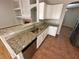 Kitchen with granite countertop peninsula and stainless steel appliances overlooking the adjacent living area at 316 Lingering Ln, Henderson, NV 89012