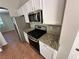 Stainless steel microwave and gas range with granite countertops and white cabinets in kitchen at 316 Lingering Ln, Henderson, NV 89012