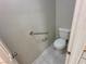 Standard toilet in bathroom with stainless steel handrails on textured white wall at 316 Lingering Ln, Henderson, NV 89012