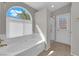 Bathroom featuring a garden tub, tiled floors, large window, and a separate walk-in shower at 3228 Jumping Hills Ave, Henderson, NV 89052