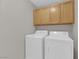 A clean laundry room features a modern washer and dryer set with cabinets overhead at 3228 Jumping Hills Ave, Henderson, NV 89052