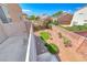 Elevated view of backyard featuring desert landscaping, greenery, rock accents, and privacy wall offering a serene outdoor space at 3425 Bedfordshire Pl, Las Vegas, NV 89129