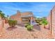 Inviting backyard with desert landscaping, lush bushes, and a covered patio, perfect for outdoor enjoyment and relaxation at 3425 Bedfordshire Pl, Las Vegas, NV 89129