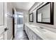 Bathroom featuring a dual sink vanity, elegant mirrors, and a view of the tiled shower area, exuding modern comfort at 3425 Bedfordshire Pl, Las Vegas, NV 89129