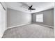 Bright, carpeted bedroom features a ceiling fan and a window, providing a comfortable and inviting space at 3425 Bedfordshire Pl, Las Vegas, NV 89129