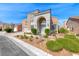 Inviting two-story home featuring an arched entryway, desert landscaping, and a well-maintained lawn on a sunny day at 3425 Bedfordshire Pl, Las Vegas, NV 89129