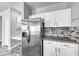 Well-lit kitchen with stainless steel refrigerator, granite countertops, and stylish backsplash at 3425 Bedfordshire Pl, Las Vegas, NV 89129