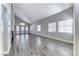 Expansive living area features high ceilings, gray wood-look floors, and large windows that provide plenty of natural light at 3425 Bedfordshire Pl, Las Vegas, NV 89129