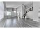 Bright living room with tall ceilings, wood-look floors, a staircase, and an arched doorway to the entrance at 3425 Bedfordshire Pl, Las Vegas, NV 89129