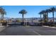 Gated community entrance featuring palm trees and a landscaped median at 377 Yellow Finch Ln, Henderson, NV 89012
