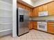 Kitchen with stainless steel fridge, wood cabinets, and granite countertops at 38 E Serene Ave # 134, Las Vegas, NV 89123