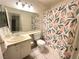 Bright bathroom with a floral shower curtain, white vanity and mirror at 3936 Rive Gauche St, Las Vegas, NV 89115