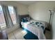 Cozy bedroom with a bed, decorative pillows, window with natural light, and tile flooring at 3936 Rive Gauche St, Las Vegas, NV 89115