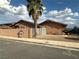Wide exterior shot of single story home, showing the corner lot with brown stucco siding and a palm tree at 3936 Rive Gauche St, Las Vegas, NV 89115