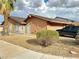 Exterior view of the house, with a manicured lawn, desert landscaping, and a two car garage in the desert at 3936 Rive Gauche St, Las Vegas, NV 89115