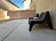 View of a blank backyard featuring a concrete patio, block wall, and two black chairs at 4825 Shea Stadium Ave, Las Vegas, NV 89139
