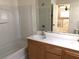 Bright bathroom featuring a double sink vanity, a shower-tub, and a view towards the staircase at 4825 Shea Stadium Ave, Las Vegas, NV 89139
