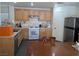 Well-lit kitchen with modern appliances, wood cabinetry, and a dining area at 4825 Shea Stadium Ave, Las Vegas, NV 89139