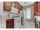 Kitchen featuring white appliances, dark wood cabinets, and a window for natural light at 4860 Nara Vista Way # 104, Las Vegas, NV 89103