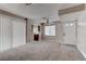 A spacious living room featuring carpet, neutral walls, backyard access, a view into the kitchen, and a ceiling fan at 4860 Nara Vista Way # 104, Las Vegas, NV 89103